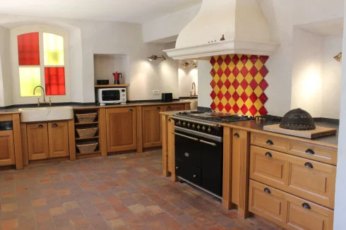 The kitchen with bespoke oak units, two stone sinks, solid brass taps, black granite work top