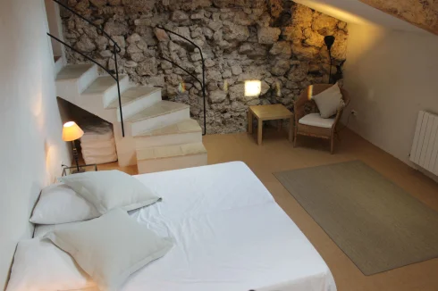 Bedroom 4 facing the garden ... Velux windows with electric blinds, exposed stone wall.