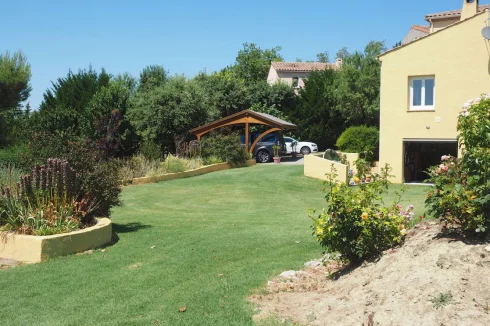 Garden with view of car port and rear of villa