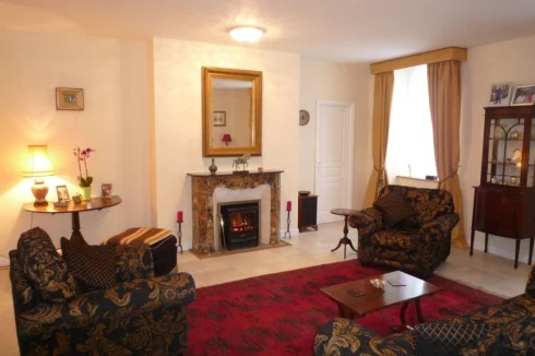 Sitting room with dual aspect windows and a feature marble fireplace