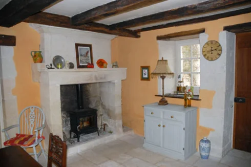 Spacious dining room with ancient fireplace and woodburning stove