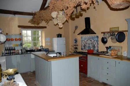 Farmhouse kitchen with original tiled floor, butler sink and granite worktops